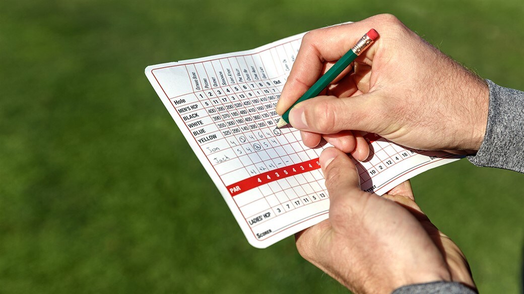 Golfer takes notes using the On-Course Golf Ball Evaluation Scorecard